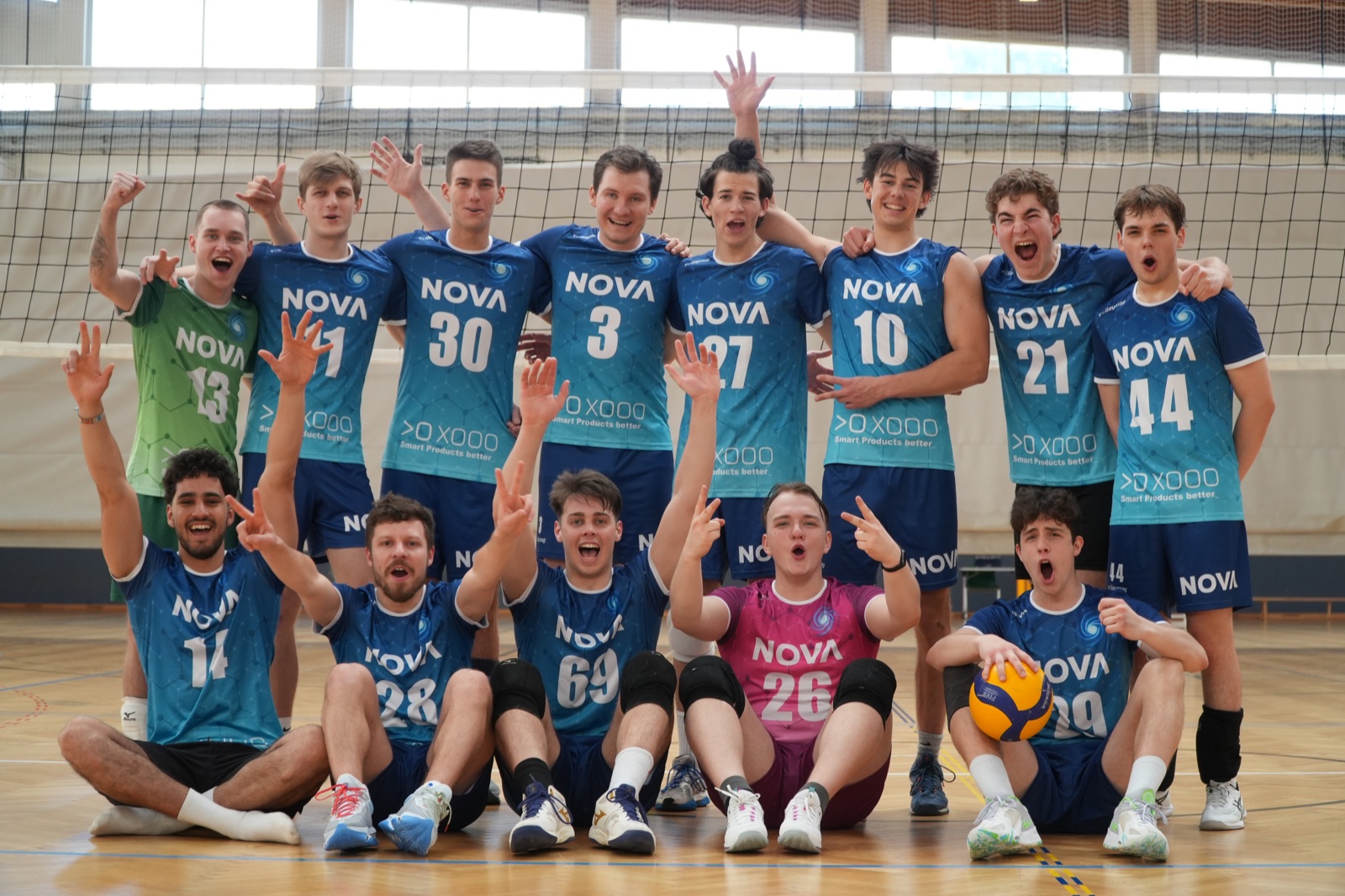 NOVA men's volleyball team celebrating together at the net